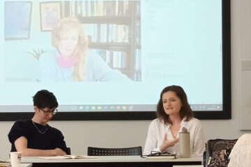 Panellists with online participant on-screen behind them.